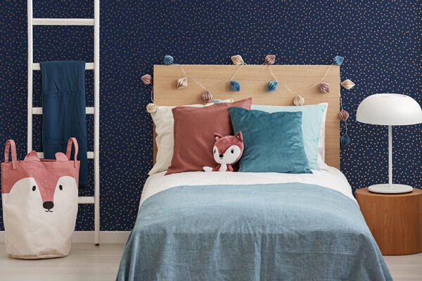 Plush fox on singe bed with colorful pillows and duvet Papel de Parede Infantil Kids n Teens 2 108561 Confetti Navy Copper “Consultar disponibilidade do Produto 19 9 8750-5835” - Imagem 1